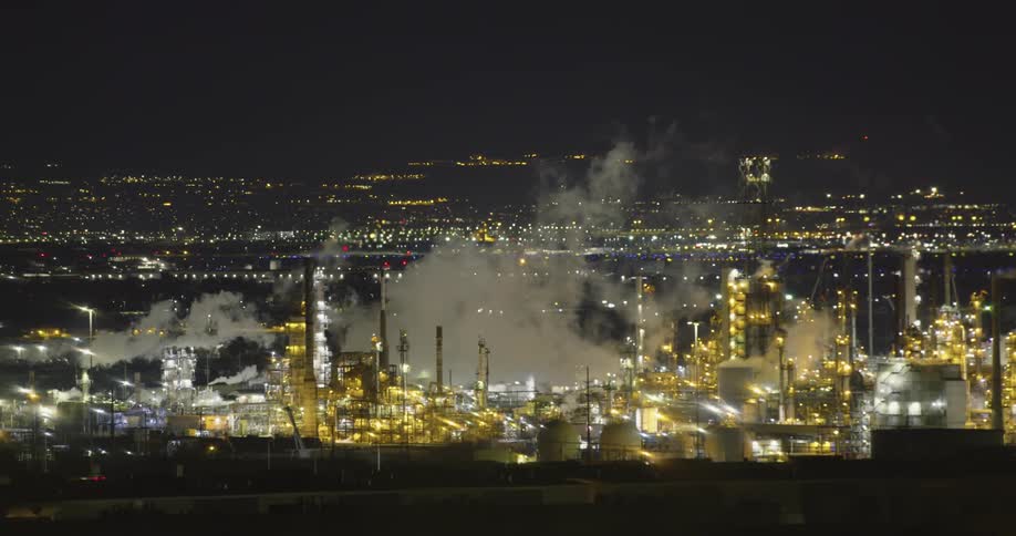 Smoke billowing from a power plant at night