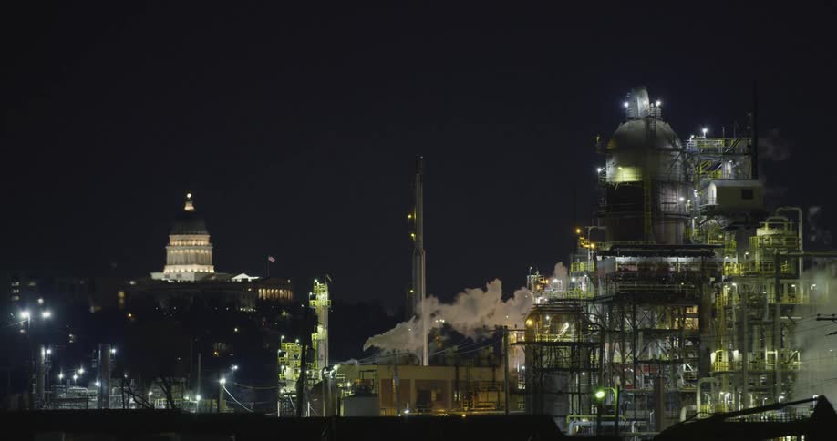 Clouds of steam and vapor rising from industrial area at night near the capitol