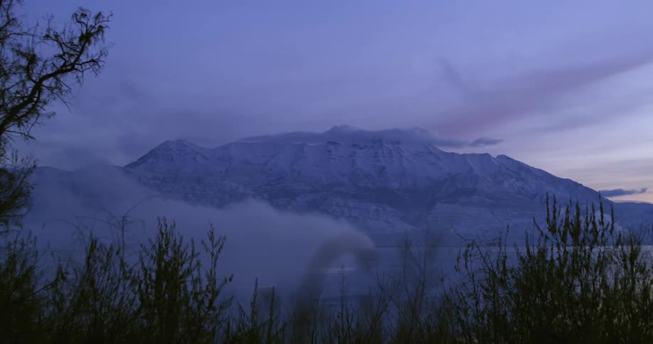 Clouds floating above a large mountain range at dawn