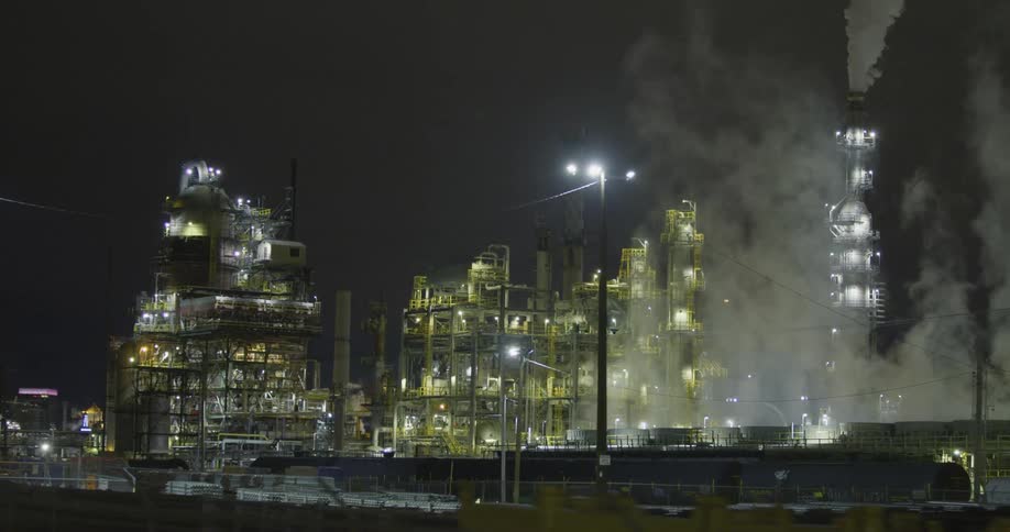 Clouds of steam and vapor rising from a power plant at night