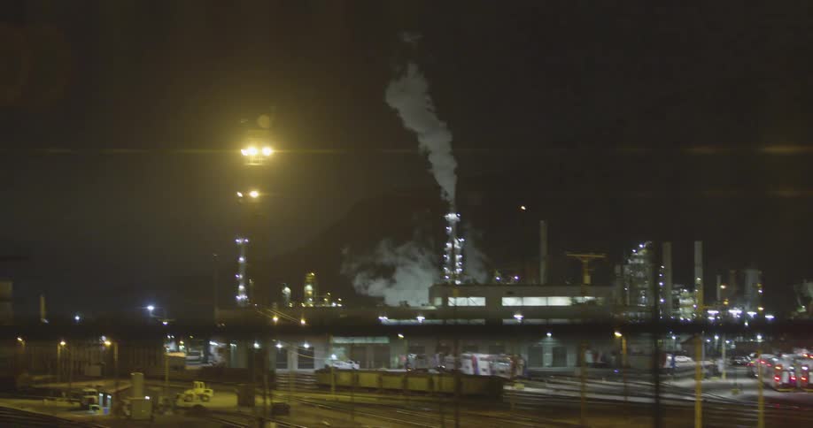 Smoke rising from a large factory at night
