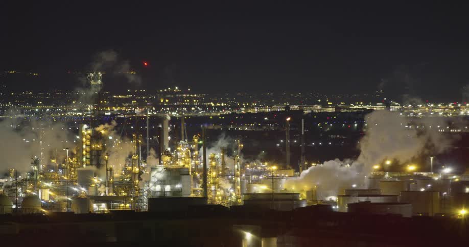 Oil Refinery with lights smoke and chimneys with the sky in the background