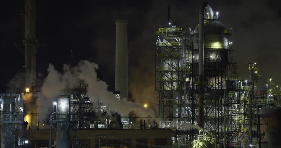 An industrial park at night with smoke in the air