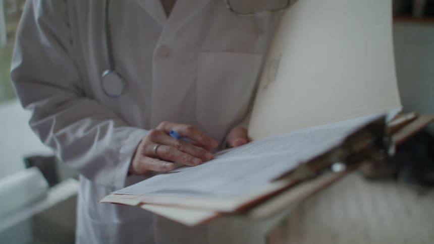 A female doctor talks to a man with both wearing masks