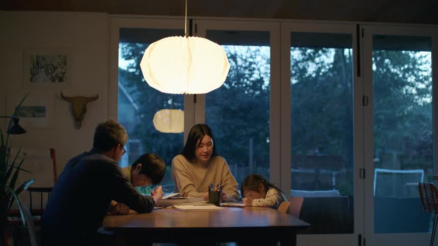 A family working on writing at a table together
