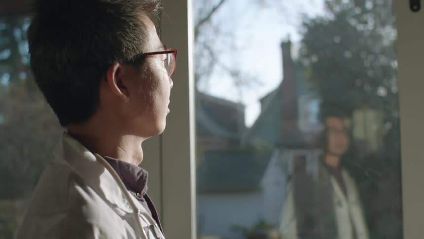 A man looking outside his window