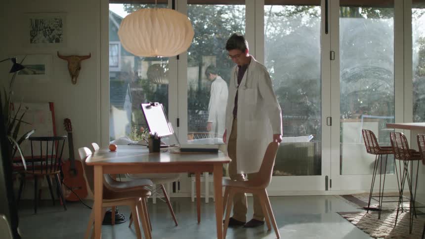 A doctor walking to a laptop