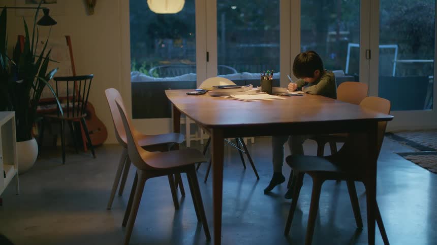 A child writing at a table