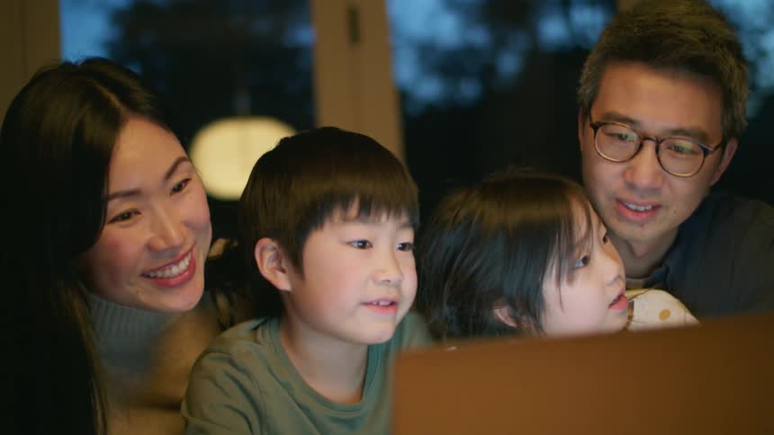 A family looking at a laptop screen while talking
