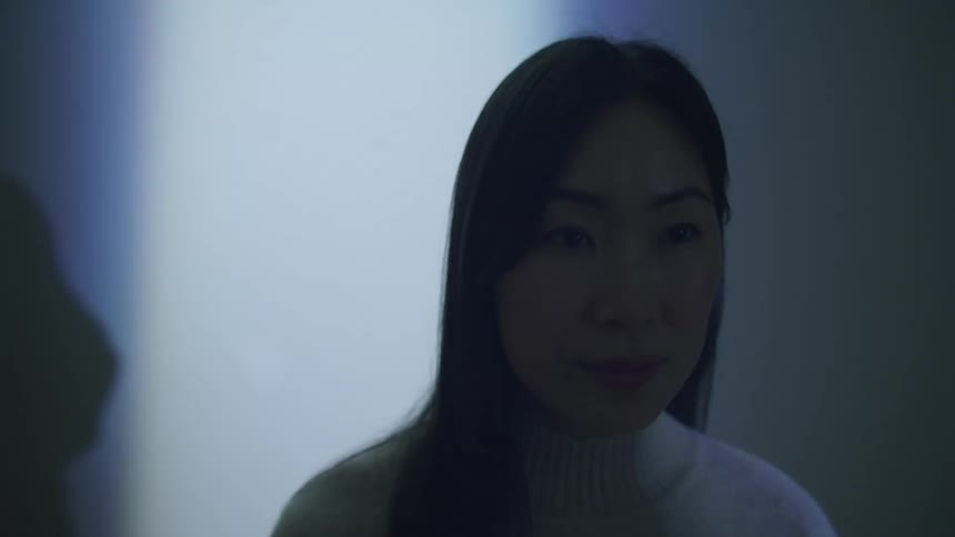 A woman sitting in a strobe light