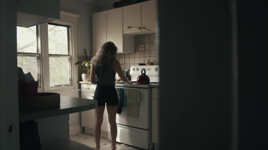 A woman wipes down her stove in her kitchen