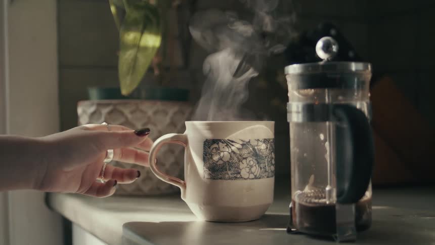 A person grabbing a coffee cup