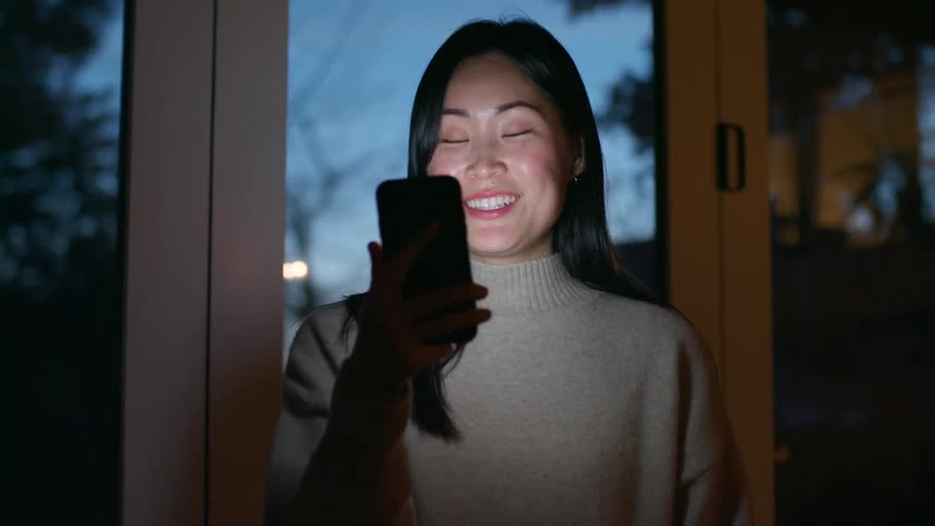 Young woman attending a video call on her smartphone at home