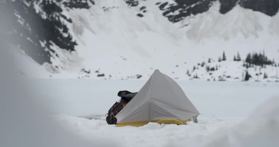 A tent sits on a snow covered field