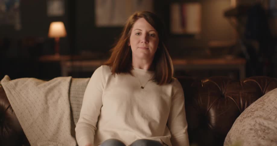 A woman sits down on a couch