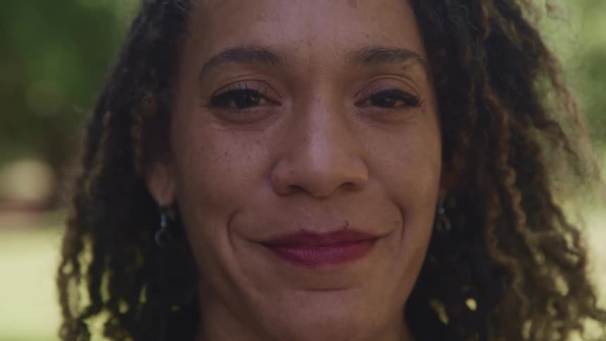 A woman turns as looks at the camera with a smile while posing for it