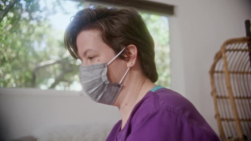 A woman with a mask on talks to someone