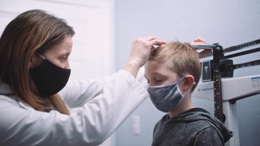 A physicians holds her had up for a high five from her nervous young patient