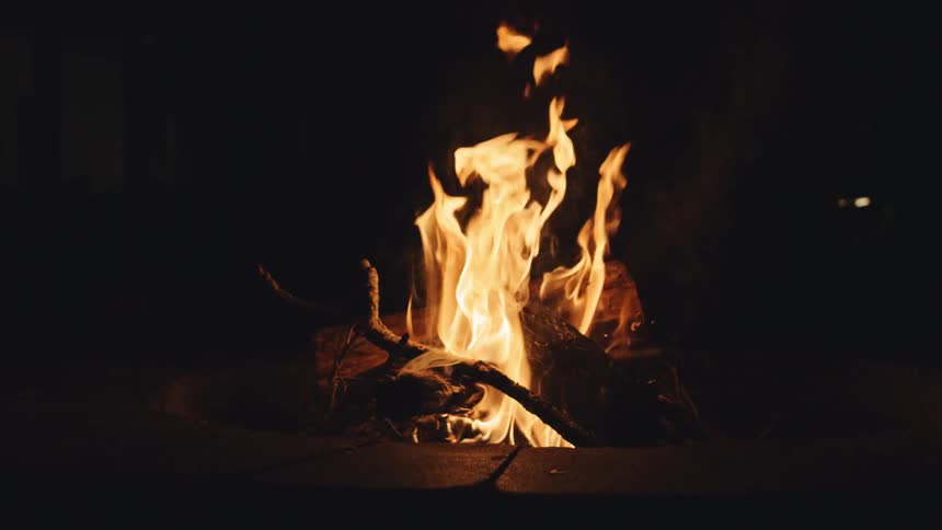 A fire burning in a fire pit at night
