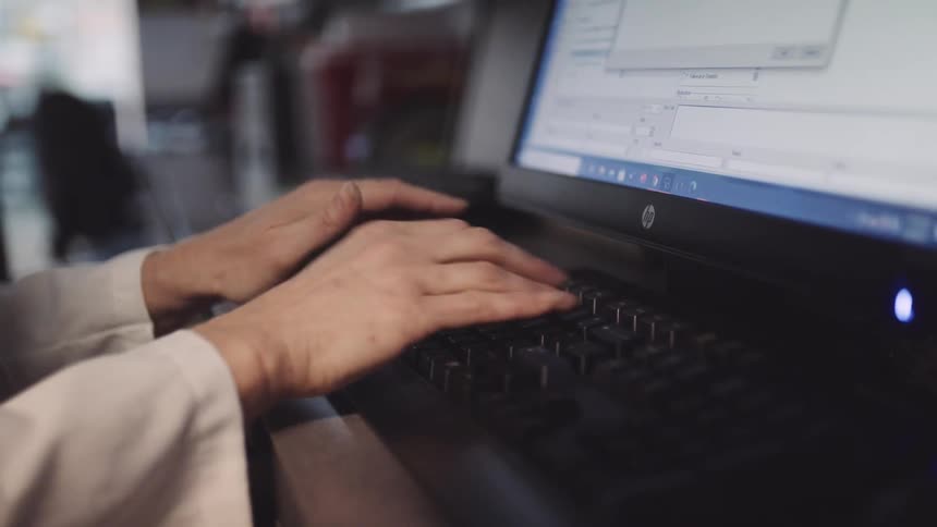 A woman types at her desk at the office