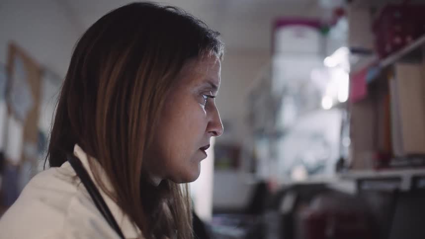 Close up of a doctors face as she sits at a desk