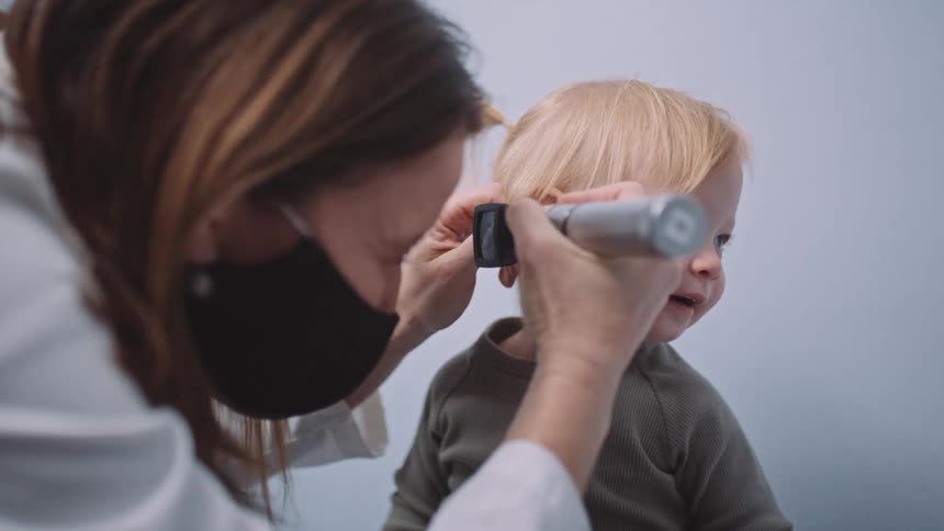 A doctor checking a babys ears with a tool