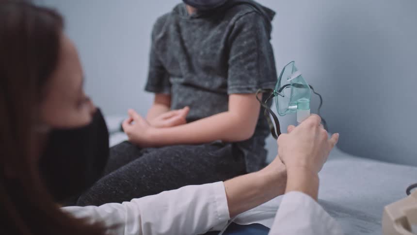 Doctor puts medical mask together to treat patient sitting near wall