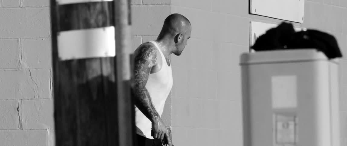 A man is walking around a building holding a gun