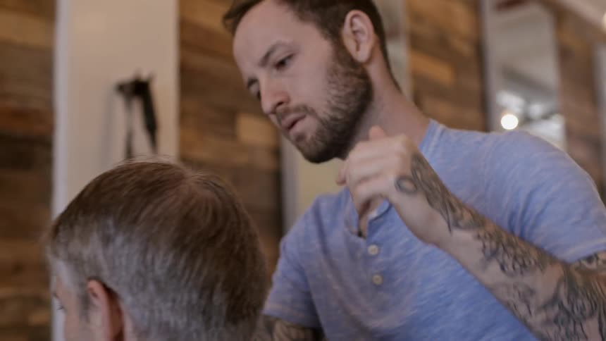 A man trimming another man's hair