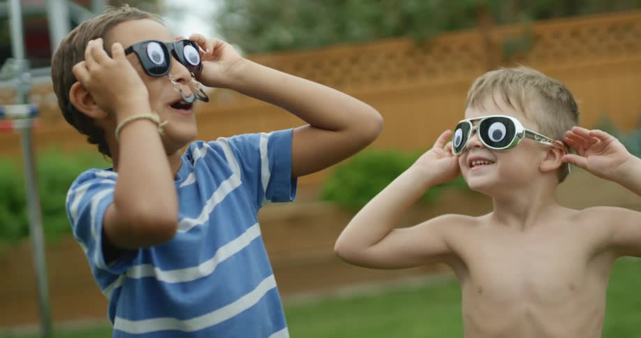 Two children playing with glasses outside