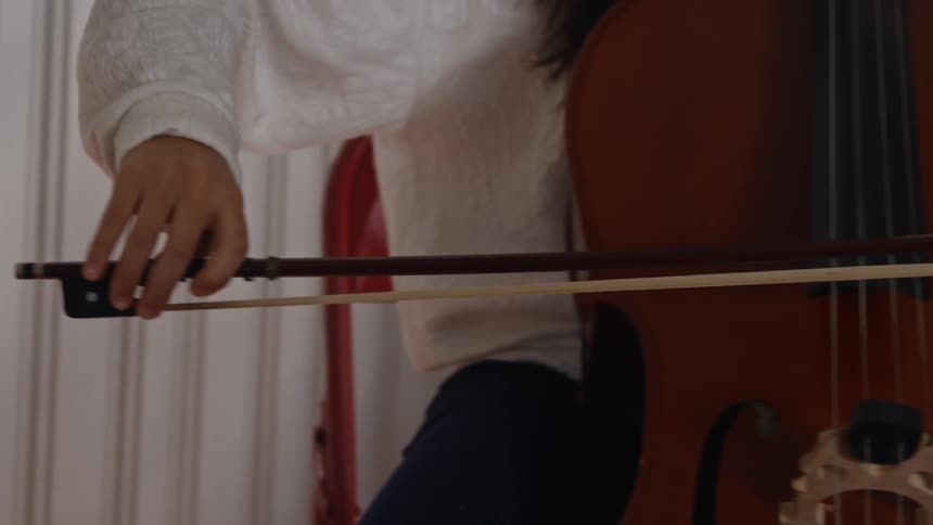 A woman is playing an instrument near a window