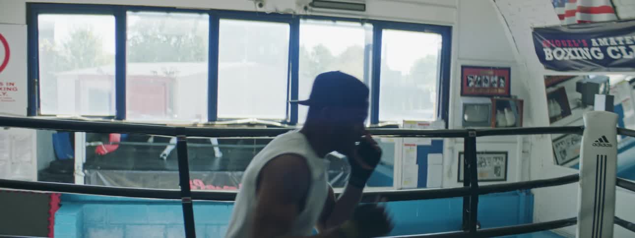 A man throws punches in a boxing ring