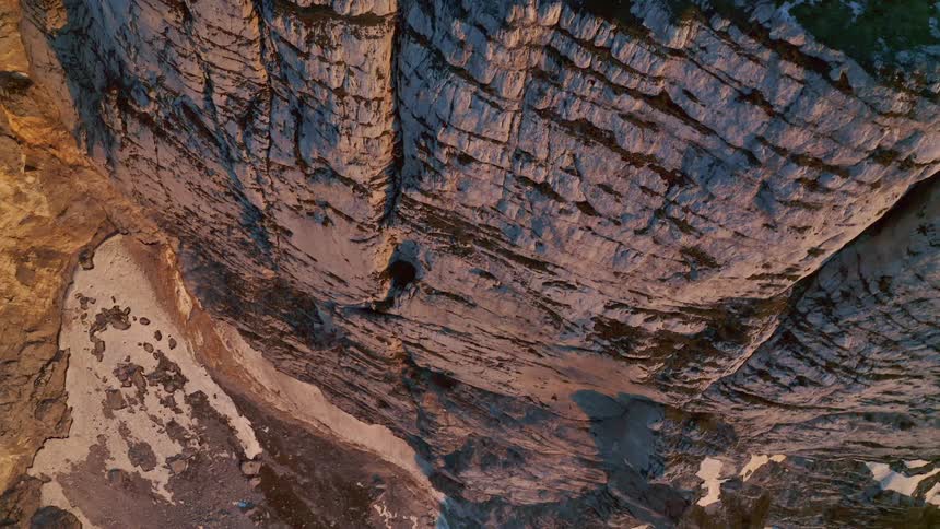 An aerial view of a tall rocky cliffside in a desert