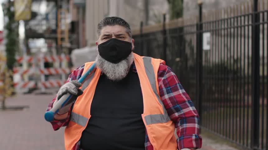 A worker lifts his sledgehammer on the street