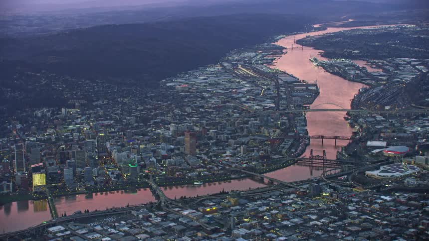 Stunning sunset aerial shot of Portland, Oregon as the pink sky illuminates the Willamette River in wonderful evening light