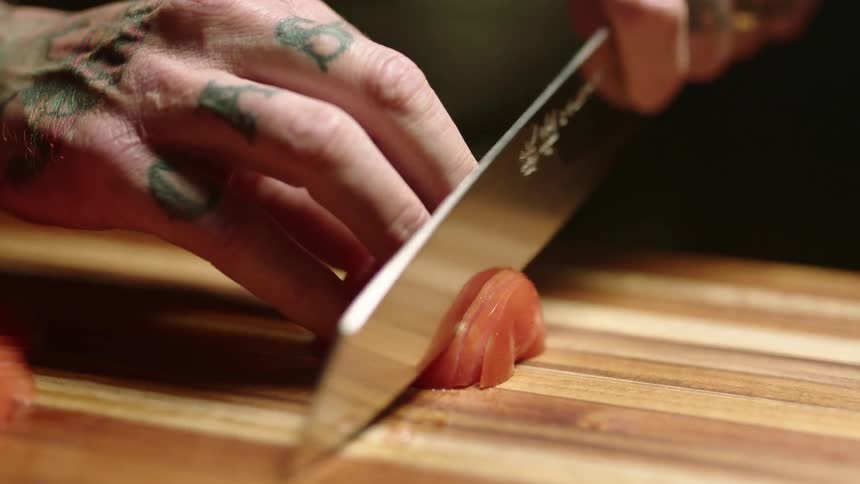 A person cutting up tomato