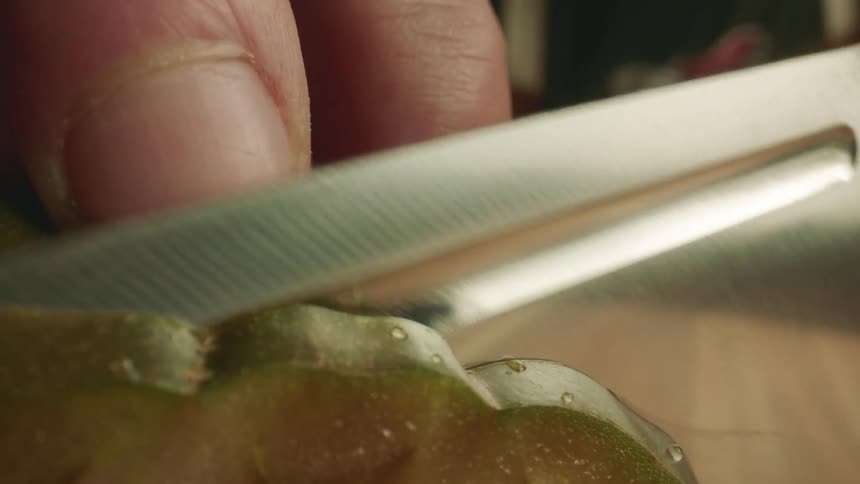 A man slices a tomato with a knife