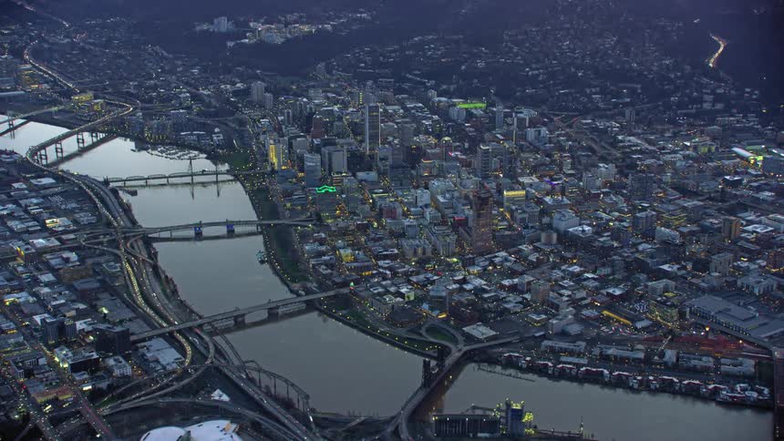 Portland, Oregon. Traffic passes through the city connected by bridges and divided by a vast and calm Willamette River