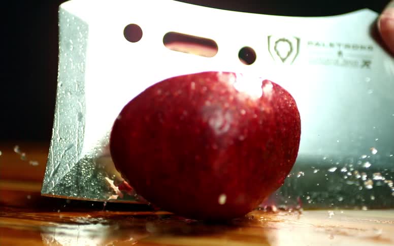 A person cutting fruit with a knife on a cutting board