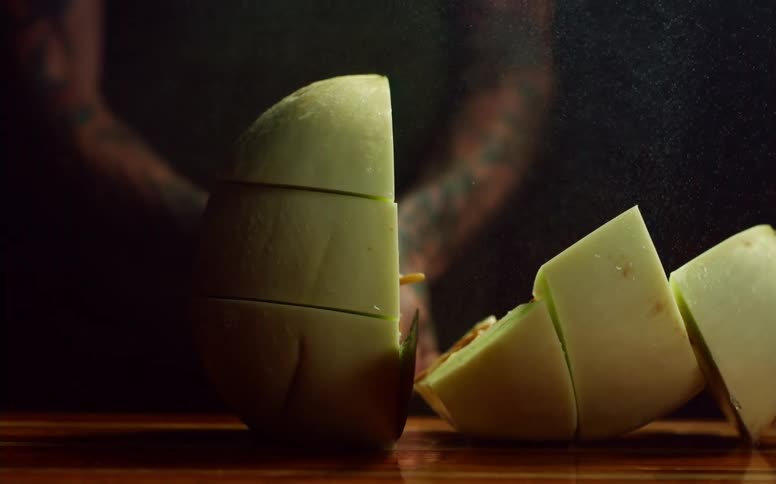 A person slicing melon in slow motion