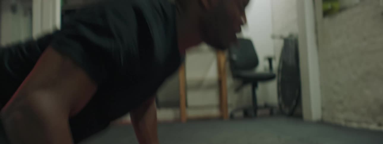 A man does push ups on a red towel at home