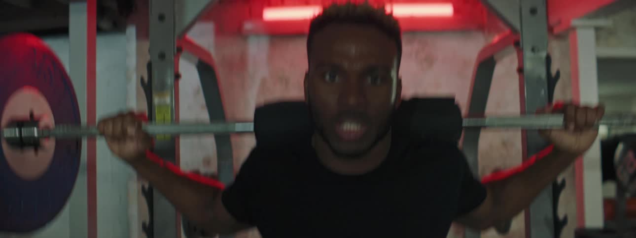 A man squatting in a gym