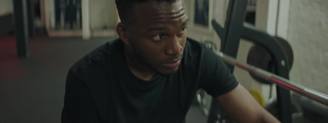 A man sitting in a gym looking around