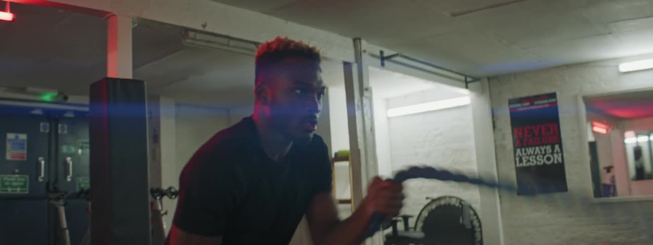 A man is exercising indoors with rope