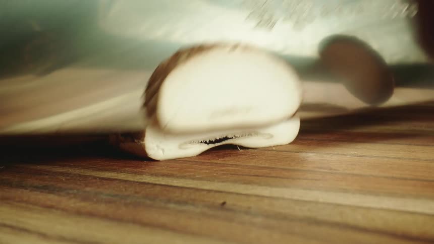 A person is slicing a mushroom