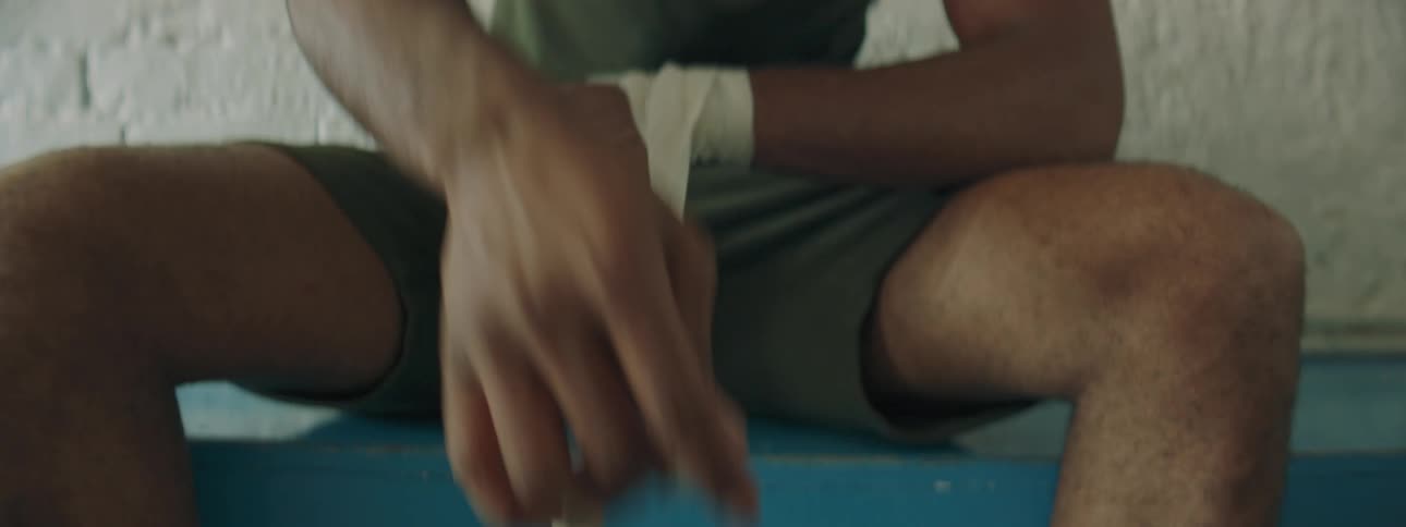A man is putting tape on his wrists