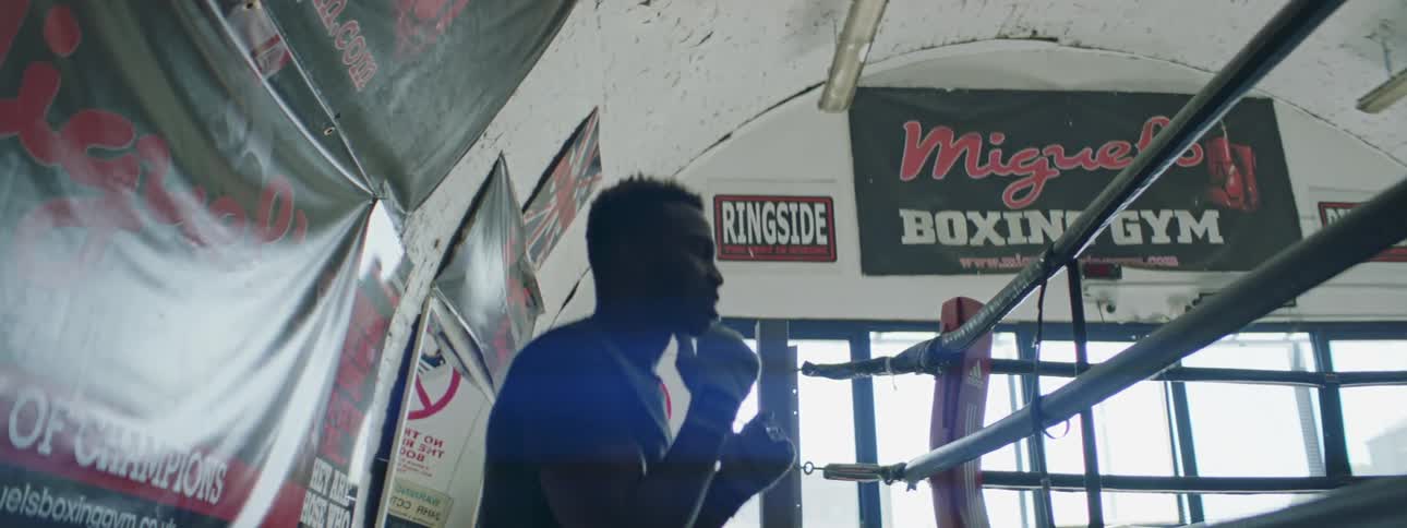 A man is jumping and punching by the ring