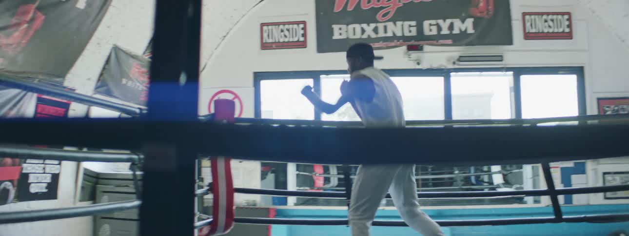 A man is boxing in a gym indoors during the day
