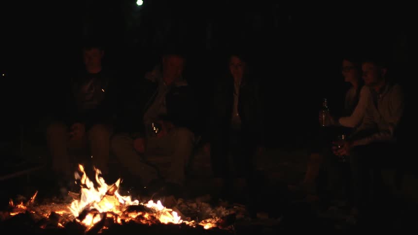 People are sitting around a campfire