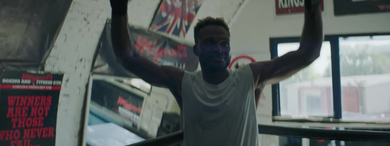 A man is walking around a gym and is happy